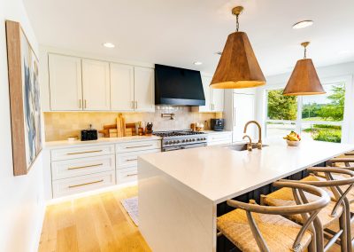 A spacious kitchen featuring a large island with a sink, surrounded by modern appliances and stylish décor.